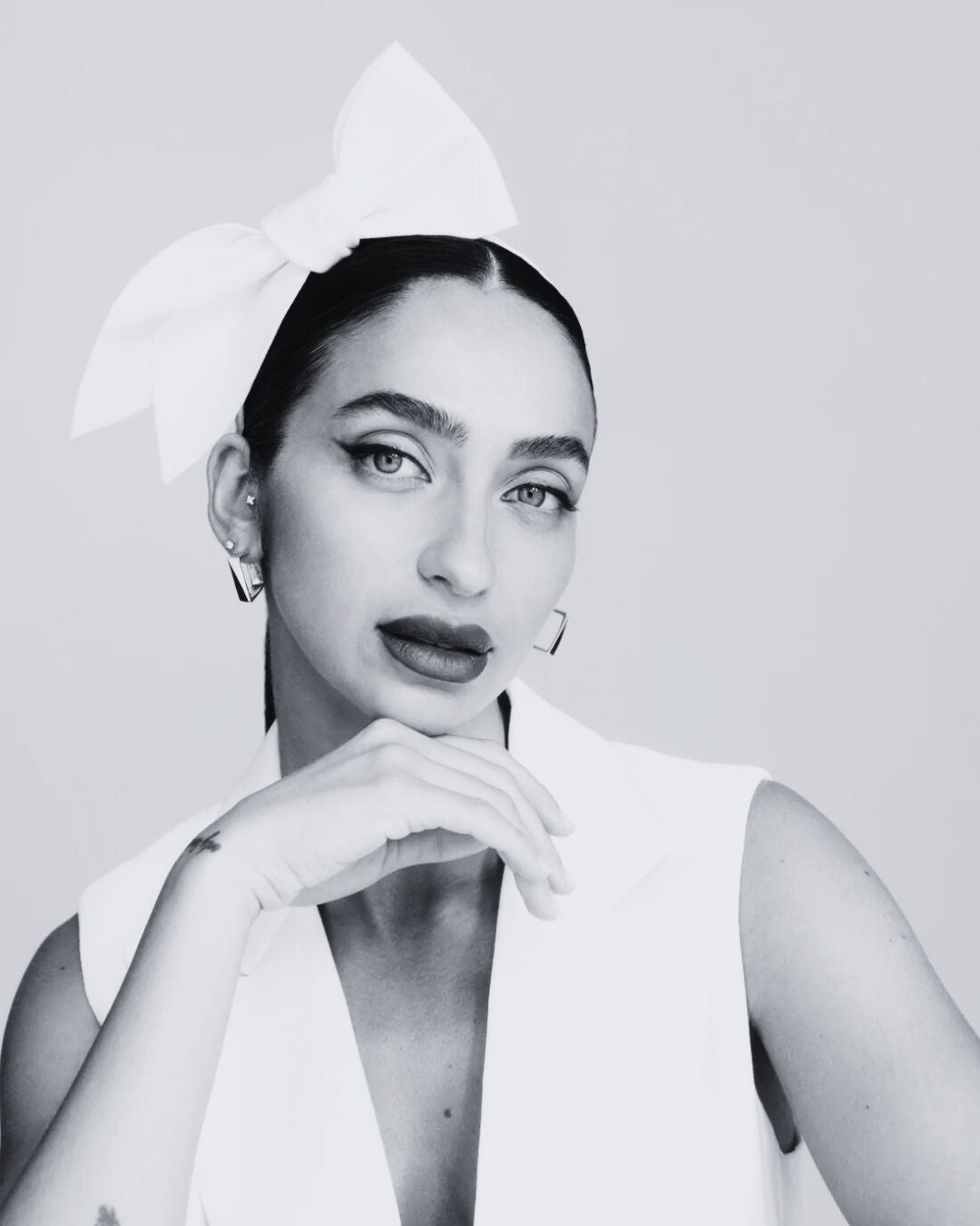 woman wears a bow headpiece in place of a bridal veil